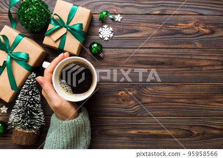 Woman holding cup of coffee. Woman hands holding a mug with hot coffee. Winter and Christmas time concept Woman holding cup of coffee. Woman hands holding a mug with hot coffee. Winter and Christmas time concept 95958566