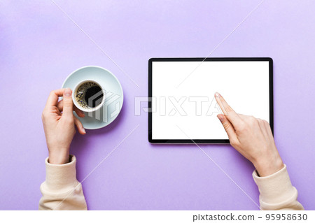 Close up image woman hands holding digital tablet with blank copy space screen for your text message or promotional content om table with cup of coffee. hands of a woman holding blank tablet device Close up image woman hands holding digital tablet with blank copy space screen for your text message or promotional content om table with cup of coffee. hands of a woman holding blank tablet device 95958630