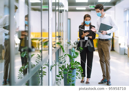 Two manager in protective face masks having an argument discussing business Issue. Covid-19. 95958710