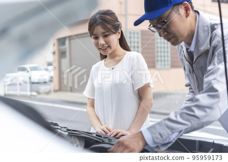 Young woman receiving advice from a mechanic Young woman receiving advice from a mechanic 95959173