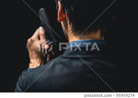 一個穿著西裝的人拿著手槍 95959274