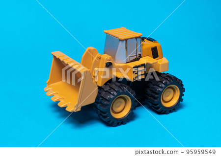 Toy typewriter tractor bulldozer on a blue background. Toy for children Toy typewriter tractor bulldozer on a blue background. Toy for children 95959549