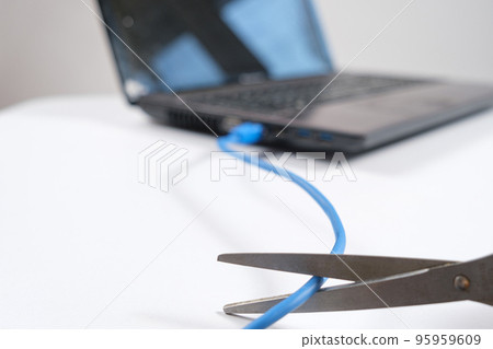 Scissors cut the Internet cable connected to the laptop. Turning off the internet, wi-fi Scissors cut the Internet cable connected to the laptop. Turning off the internet, wi-fi 95959609