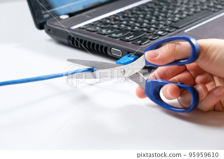 Scissors cut the Internet cable connected to the laptop. Turning off the internet, wi-fi Scissors cut the Internet cable connected to the laptop. Turning off the internet, wi-fi 95959610