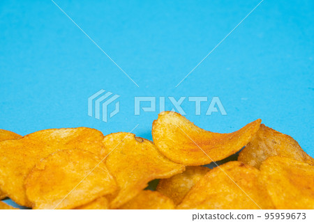 Delicious crispy potato chips with spices on a blue background, place for text Delicious crispy potato chips with spices on a blue background, place for text 95959673