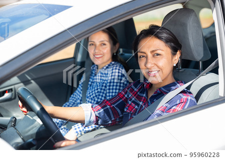 Smiling Colombian woman driving car Smiling Colombian woman driving car 95960228