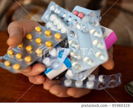 many different pills and medicines in the hands of an old man many different pills and medicines in the hands of an old man 95960328