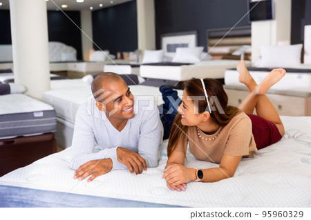 Man and woman choosing mattress in store trying it 95960329