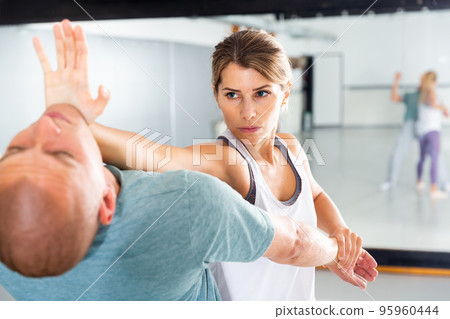 Woman practicing basic palm strike in self defense training 95960444