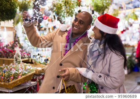 Cheerful man and woman buying christmas balls together at christmas fair 95960689
