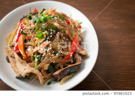 japchae or stir-fried Korean vermicelli noodles with vegetables and pork topped with white sesame 95961025