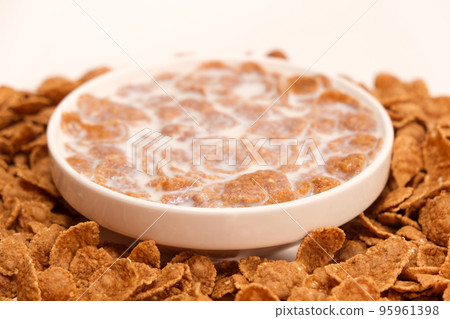 Cereal flakes drenched in milk in a plate, close-up. Healthy delicious dairy breakfasts for children and adults. Cereal flakes drenched in milk in a plate, close-up. Healthy delicious dairy breakfasts for children and adults. 95961398