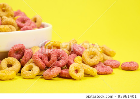 Quick cereal breakfast in the form of rings on a plate on a yellow background Quick cereal breakfast in the form of rings on a plate on a yellow background 95961401