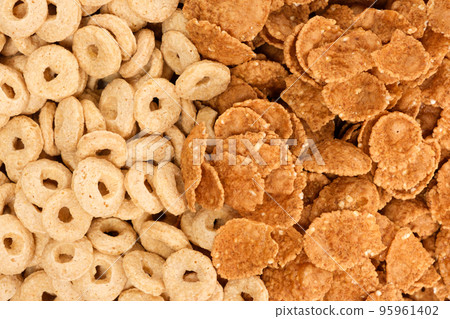 Close-up of wheat flakes and corn rings, top view. Close-up of wheat flakes and corn rings, top view. 95961402