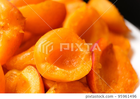 Juicy apricot slices on a black background, side view. Juicy apricot slices on a black background, side view. 95961496