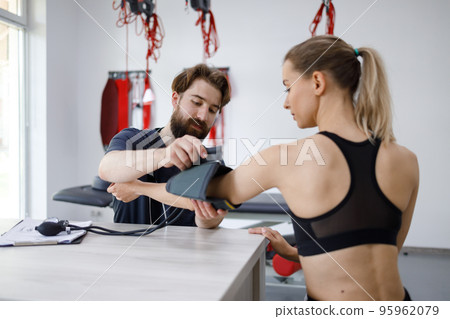 Young woman checks blood pressure at the physiotherapist's office 95962079