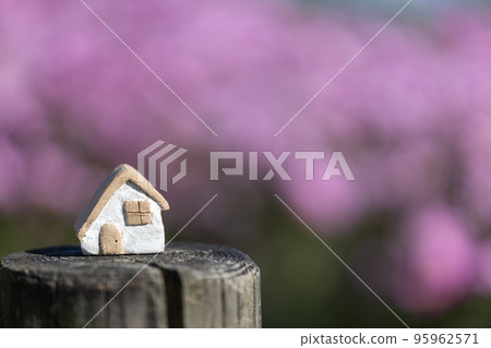 Small cute unglazed pottery house with pink cosmos background Small cute unglazed pottery house with pink cosmos background 95962571