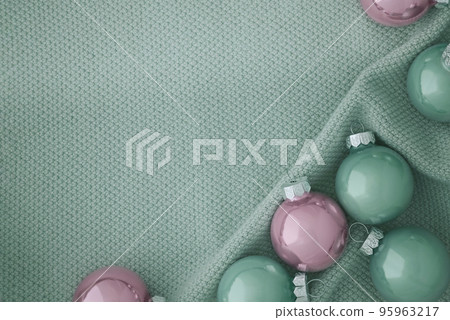 Beautiful Christmas balls in soft pink and mint colors on a knitted mint fabric. 95963217
