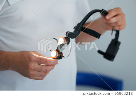 Dental binocular loupes in dentist hands 95963218