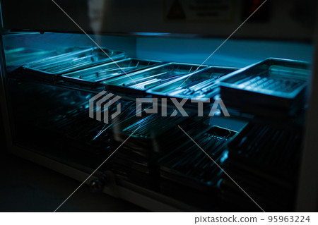 Steel dental instruments lying in a sterilizer under ultraviolet 95963224