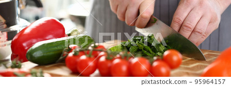 Man chef cutting greenery on wooden board, add ripe vegetable to salad Man chef cutting greenery on wooden board, add ripe vegetable to salad 95964157
