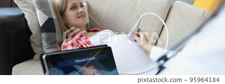 Gynecologist doing ultrasound scan on belly using modern digital ultrasound machine with tablet 95964184