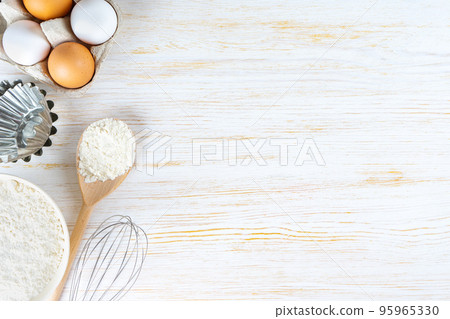 Baking ingredients flour, eggs, milk, bakeware on white wooden background with copy space Baking ingredients flour, eggs, milk, bakeware on white wooden background with copy space 95965330