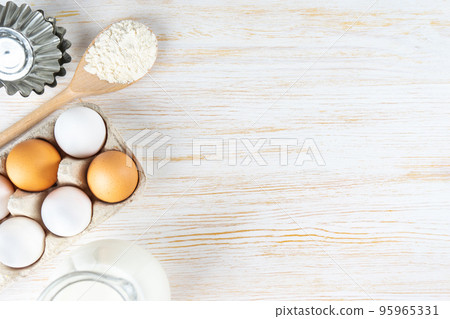 Baking ingredients flour, eggs, milk, bakeware on white wooden background with copy space Baking ingredients flour, eggs, milk, bakeware on white wooden background with copy space 95965331
