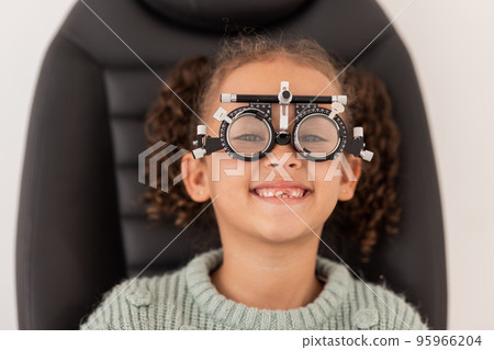 Trial frame, vision and eye test of girl at hospital or optometry clinic for eyewear, health and eye wellness. Exam, glasses and child testing eyesight for new optical lenses, frames or spectacles. 95966204