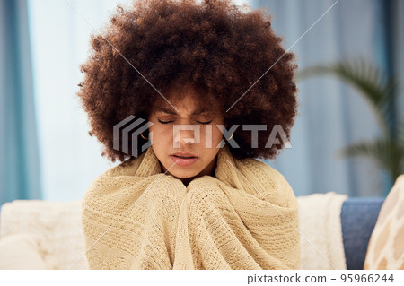 Cold, winter and black woman with blanket on sofa to keep warm, cozy and stop shivering. Sick, covid and girl with flu symptoms sitting on couch freezing from low body temperature, illness and fever 95966244