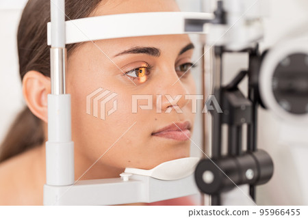 Vision, eyesight and woman gets ophthalmology eye exam with light on iris testing to see sight. Healthcare, medical insurance and eyes, girl getting healthy visual refraction eye test at clinic. Vision, eyesight and woman gets ophthalmology eye exam with light on iris testing to see sight. Healthcare, medical insurance and eyes, girl getting healthy visual refraction eye test at clinic. 95966455