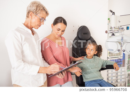 Mother and child consulting an eye doctor with a clipboard after an eye test or exam for healthy vision. Family, optometrist or optician helping a mom and kid with eyesight advice or eye care results 95966708