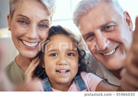 Interracial family, selfie and girl with grandparents at home feeling happy with love and care. Portrait of senior people with an adopted kid bonding together at a house busy with youth care 95966830
