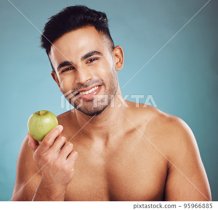 Diet, apple and portrait of man for a healthy lifestyle for health and wellness. Fruit, raw and organic produce for vitamins and healthy living with nutrition on a blue studio background. Diet, apple and portrait of man for a healthy lifestyle for health and wellness. Fruit, raw and organic produce for vitamins and healthy living with nutrition on a blue studio background. 95966885