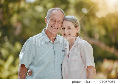 Happy, love and portrait of a senior couple standing in a green garden while on a picnic on vacation. Happiness, smile and elderly man and woman in retirement embracing in a park on holiday in Canada Happy, love and portrait of a senior couple standing in a green garden while on a picnic on vacation. Happiness, smile and elderly man and woman in retirement embracing in a park on holiday in Canada 95967065