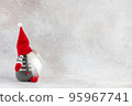 Christmas handmade gnome in red hat side view holiday banner on light winter background 95967741