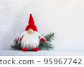 Christmas gnome in red cap with fir branch holiday card on light winter background 95967742