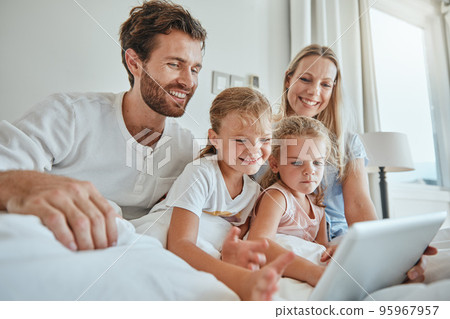 Family, bed and tablet with children and parents streaming an online subscription in the bed at home. Kids, internet and video with a man, woman and daughter siblings watching series in the bedroom Family, bed and tablet with children and parents streaming an online subscription in the bed at home. Kids, internet and video with a man, woman and daughter siblings watching series in the bedroom 95967957