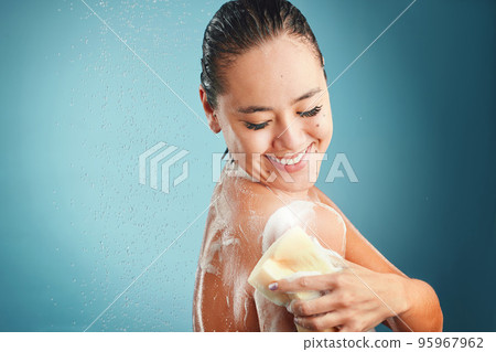 Shower, sponge and soap with a woman cleaning her body in studio on a blue background with mockup. Water, hand and wellness with an attractive young female washing in the bathroom for hygiene 95967962