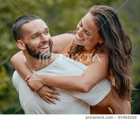 Piggy back, couple and happy hug of a man and woman in nature with love, care and happiness. People with a smile and play together smiling about romantic anniversary and loving relationship outdoor Piggy back, couple and happy hug of a man and woman in nature with love, care and happiness. People with a smile and play together smiling about romantic anniversary and loving relationship outdoor 95968088