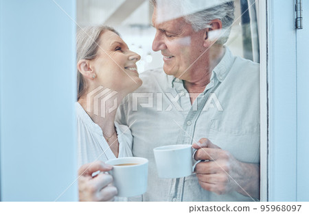 Retirement, coffee and love with a senior couple drinking or enjoying a beverage together in their home. Relax, romance and bonding with an elderly man and woman pensioner by a door in their house Retirement, coffee and love with a senior couple drinking or enjoying a beverage together in their home. Relax, romance and bonding with an elderly man and woman pensioner by a door in their house 95968097