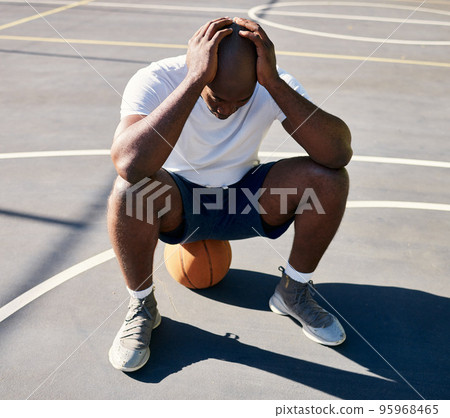 Basketball, sports and depressed man on court with hands on head after loss, fail and bad game. Fitness, sadness and upset black man sitting on ball on outdoor basketball court, frustrated and mad 95968465