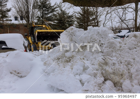 Snow blizzard clean up of snow with tractor after huge snowstorm in winter time Snow blizzard clean up of snow with tractor after huge snowstorm in winter time 95968497