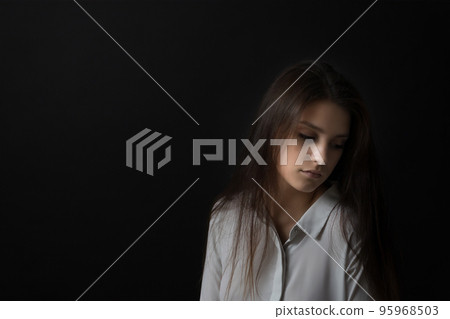Low key studio portrait of sad girl. Low key studio portrait of sad girl. 95968503