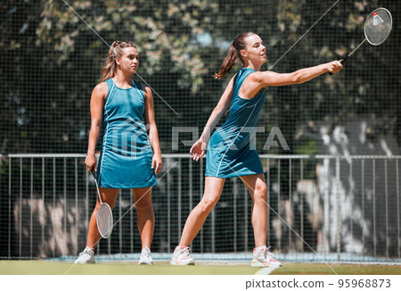 Badminton, sports and women with a serve on an outdoor court busy with fitness and exercise. People training, cardio and athlete workout of sport student teamwork and collaboration together 95968873