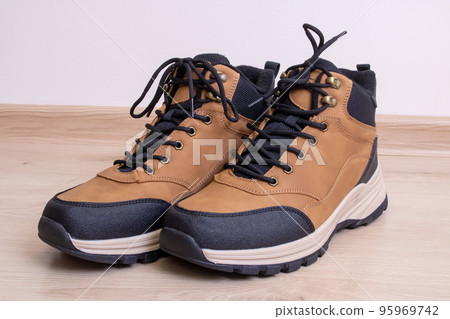Men's brown boots on a wooden floor 95969742