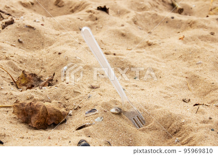 Plastic fork in the sand on the beach 95969810