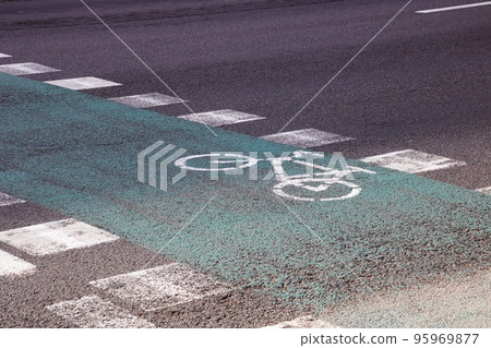 Green marked bike path on asphalt closeup 95969877