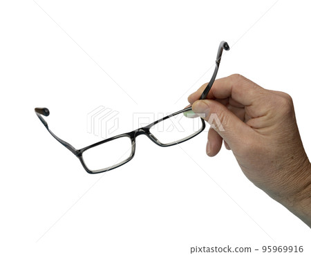 a pair of eyeglasses in a man's hand a pair of eyeglasses in a man's hand 95969916