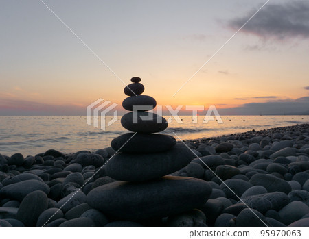 Stack of zen stones on the beach at sunset, beautiful seascape. Made of stone tower as rest balance vacation concept. 95970063